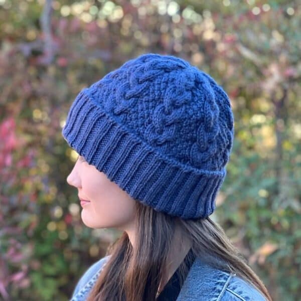 Blue knitted beanie hat with folded brim shown side